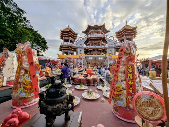 鷄笼中元祭18日晚间在中正公园的主普坛前举行公普，今年轮值主普的张廖简宗亲会准备了三连桌及丰富的看桌以飨各方的老大公。（张志康摄）