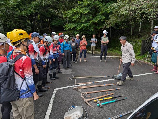 伍玉龙（右一）带领大家认识手作步道的器具。（林业署台中分署提供／李京升台中传真）