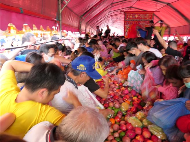 雲林縣北港朝天宮「慶讚中元普渡法會」，由朝天宮青果鋪提供「水果山」，中元節當天下午5點開放「搶水果」，有人裝滿整個大塑膠袋，有全家動員以接龍方式搶水果，各出奇招。（張朝欣攝）