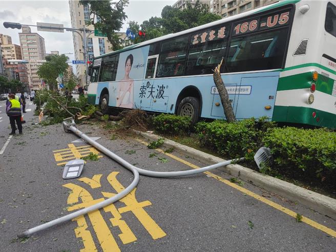 公車撞上集賢路中央分隔島，一座路燈連根拔起。（新北市消防局提供）