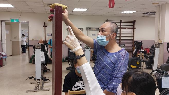 物理治疗师廖瑀璇进行站立重心移动训练。（院方提供／李京升台中传真）