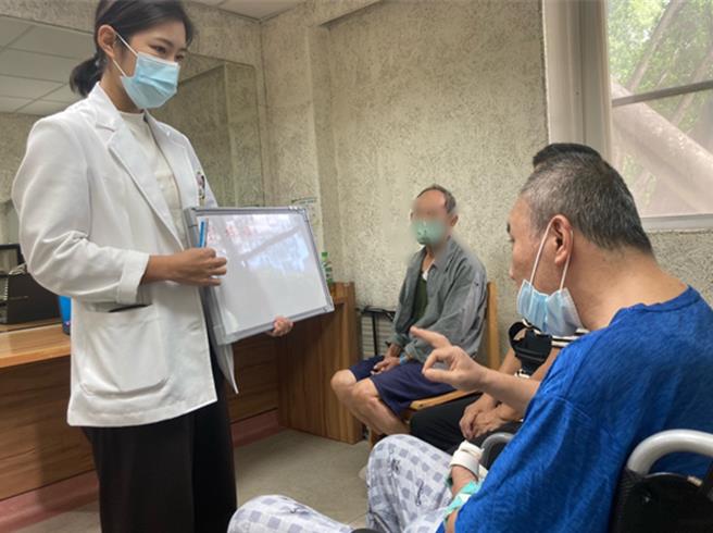 语言治疗师赖品嫙进行认知与口语对答训练。（院方提供／李京升台中传真）