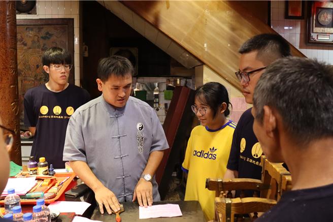 法师解说神意。（翻摄照片／洪靖宜高雄传真）