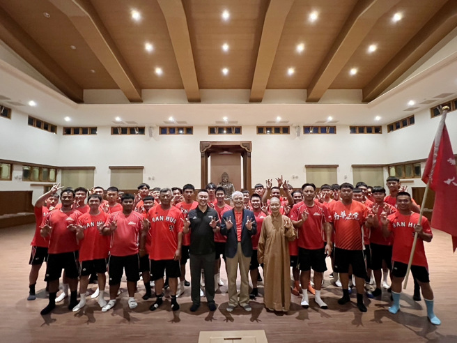 行前由覺禹法師、校長高俊雄及體育長何應志授旗給棒球隊。（照片/南華大學提供）