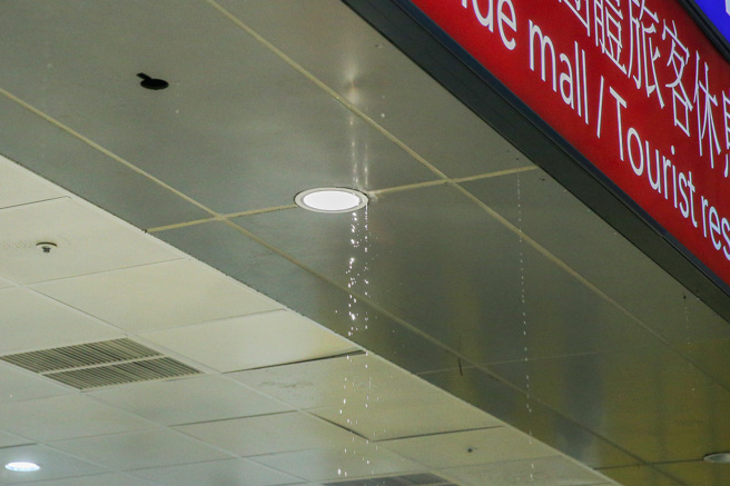 桃园国际机场20日下午3时许，在第二航厦出境大厅21号报到柜台旁的整排走道天花板发生爆管漏水情况。（陈麒全摄）