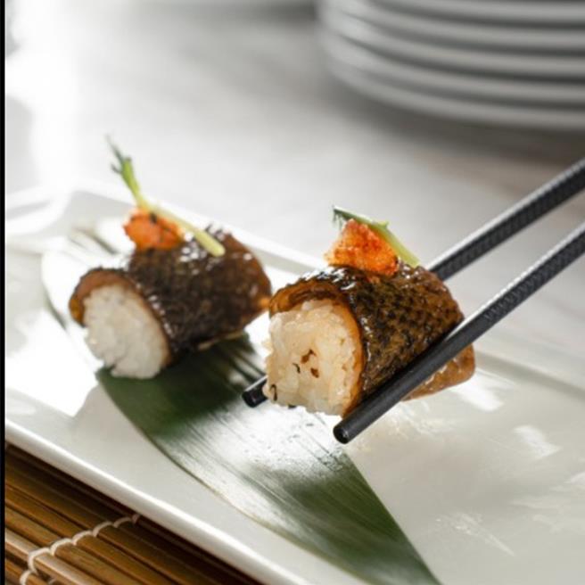 「虱目鱼皮寿司」以富含胶质的虱目鱼皮，搭配寿司米的酸甜味和轻微的芥末辣味，整体风味清新且层次丰富，是一道中日融合的创意料理。(台南大员皇冠假日酒店提供)