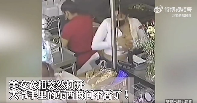 女店員伸手拿物品給購買的大爺時，胸前鈕扣突然罷工！整件襯衫繃開，差點春光外洩。（圖／翻攝微博）