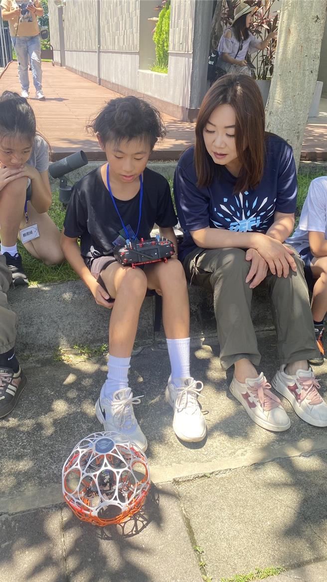 學員經過指導操作無人機，為立委馬文君講解操作無人機的技巧及注意事項。（楊靜茹攝）