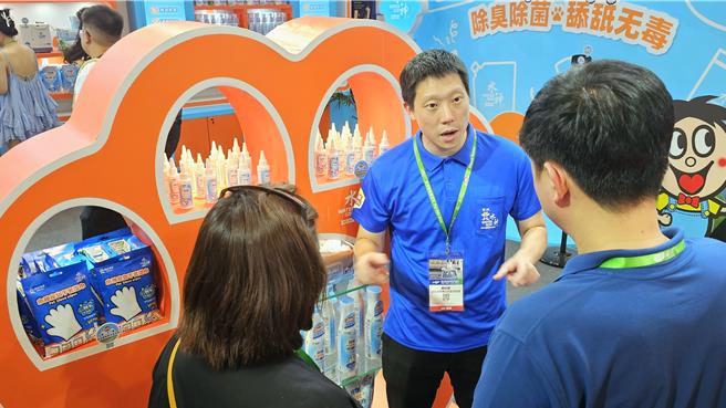 旺旺集团水神事业部总经理蔡旺庭（中）21日在宠物展会场替来访客户解说产品。（吴泓勋摄）