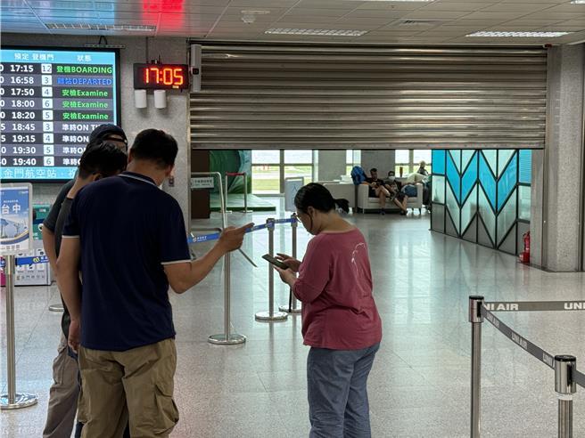 金門尚義機場大廳今日下午接近16時40分左右，不明原因突然警鈴大響，導致西側大廳整面鐵捲門「無預警關門」，上百旅客「霧煞煞」受困其內全嚇傻。(于家麒攝)