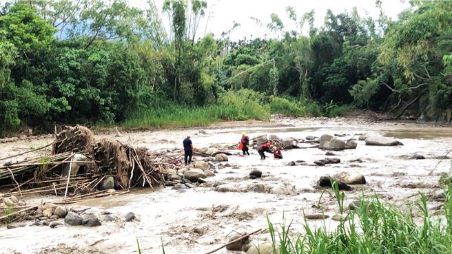 消防人员前往救援，架设绳索冒险涉过湍急黄泥水，协力救出钓客。（嘉县消防局提供∕吕妍庭嘉义传真）