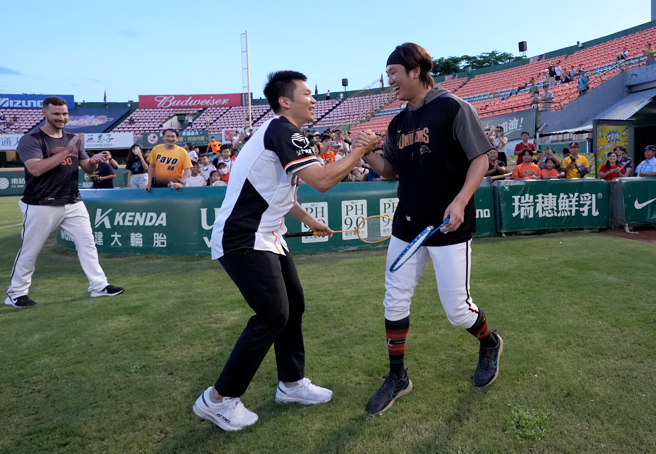 在巴黎奧運打下羽球男雙金牌的李洋（左）與統一獅投手古林睿煬相見歡。（統一獅提供）