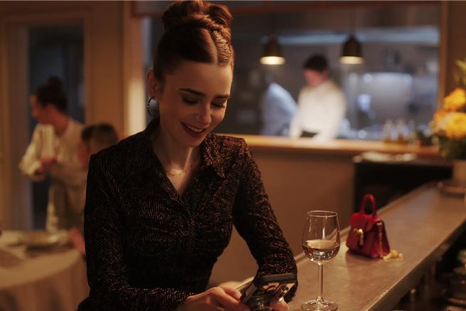 艾蜜莉在第四季第四集中，穿著華麗性感小洋裝，手拿Delvaux迷你Toy提包等心愛的加百列下班。（Netflix提供／黃唯淯台北傳真）