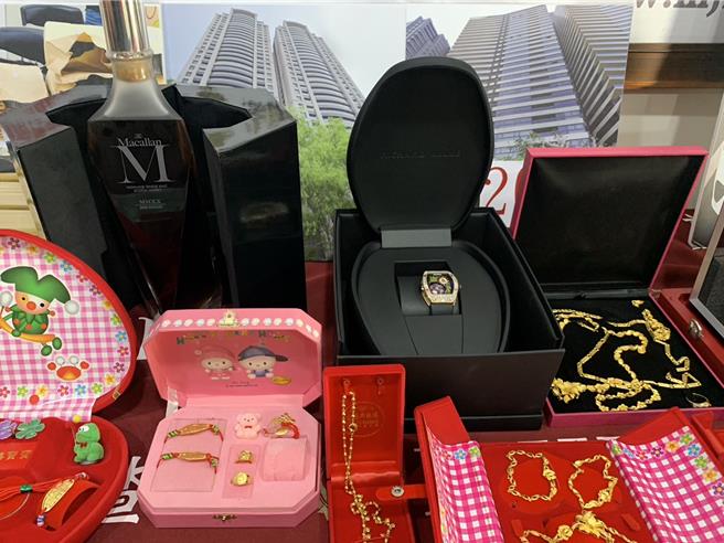 调查局展示查扣的名表、金饰和名酒、房产契约等。（郭良杰摄）