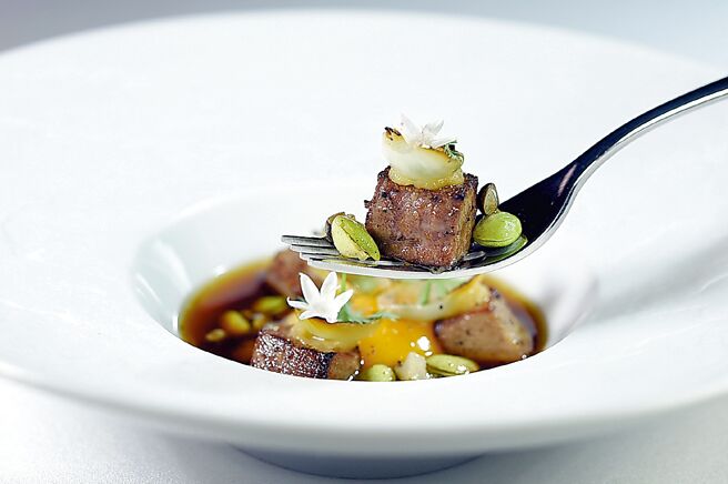 以西式〈牛尾汤〉结合〈寿喜烧〉为创作灵感的〈炭烤牛舌／牛尾清汤／柑橘〉，牛舌慢煮后调味炭烤，搭配炭烤毛豆与油封蛋黄，呼应寿喜烧肉片佐蛋黄的意境，最后点缀柑橘青花椒油赋予整道汤品独特香气。图／姚舜