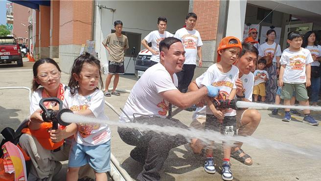 桃园市山脚消防分队今与直佑营造公司联合举办消防宣导夏令营活动，120位亲子共襄盛举，不但和搜救犬同乐、也体验消防负重亲子竞赛、横渡斜降、灭火器暨射水等。(蔡依珍摄)