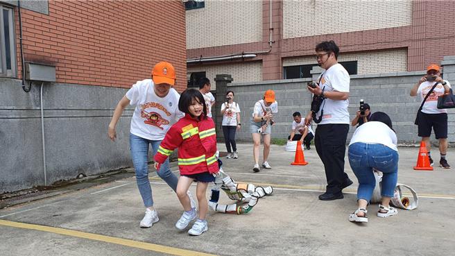 桃园市山脚消防分队今与直佑营造公司联合举办消防宣导夏令营活动，120位亲子共襄盛举，不但和搜救犬同乐、也体验消防负重亲子竞赛、横渡斜降、灭火器暨射水等。(蔡依珍摄)