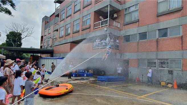 桃园市山脚消防分队今与直佑营造公司联合举办消防宣导夏令营活动，120位亲子共襄盛举，不但和搜救犬同乐、也体验消防负重亲子竞赛、横渡斜降、灭火器暨射水等。(蔡依珍摄)