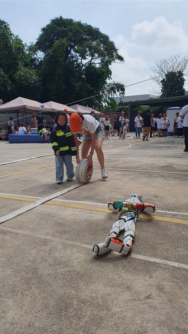 桃园市山脚消防分队今与直佑营造公司联合举办消防宣导夏令营活动，120位亲子共襄盛举，不但和搜救犬同乐、也体验消防负重亲子竞赛、横渡斜降、灭火器暨射水等。(蔡依珍摄)