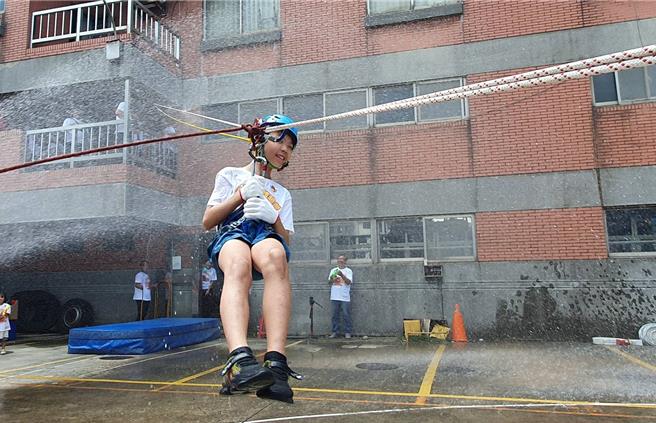桃园市山脚消防分队今与直佑营造公司联合举办消防宣导夏令营活动，120位亲子共襄盛举，不但和搜救犬同乐、也体验消防负重亲子竞赛、横渡斜降、灭火器暨射水等。(蔡依珍摄)