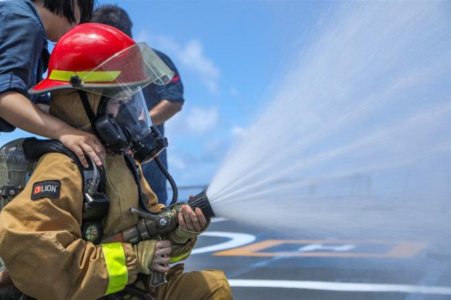 學子們實際穿著防火裝備，體會海軍官兵訓練辛勞。（記者林睿奕攝）