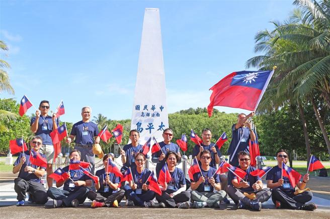 「113年全民國防教育南沙研習營」教師們手持國旗於太平島上合影留念，見證我國南海主權。（記者劉宸瑋攝）
