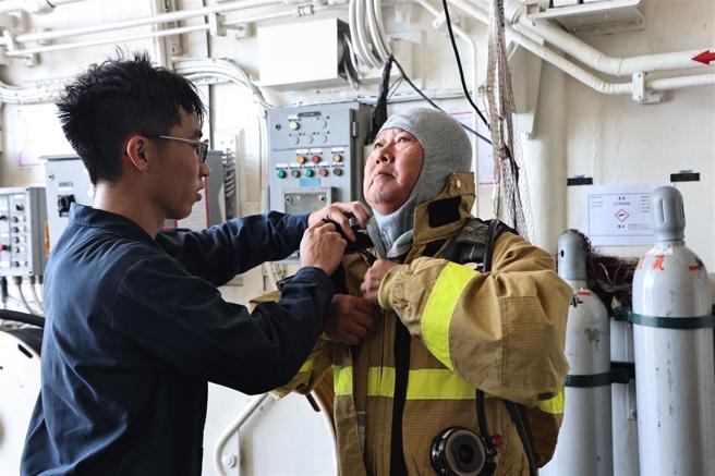 教師實際穿著防火裝備，體會海軍官兵訓練辛勞。
（記者劉宸瑋攝）