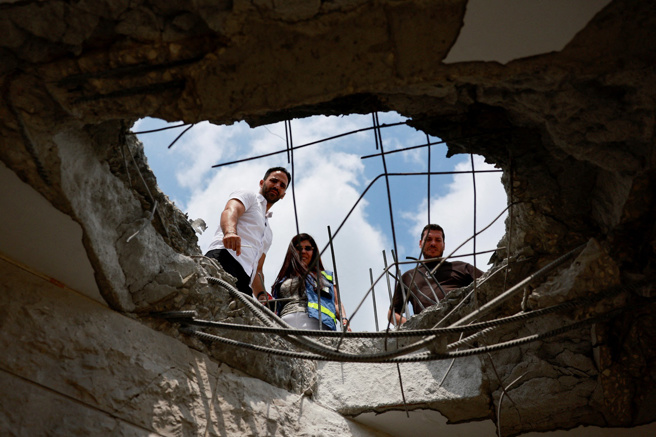 继25日对以色列发射「火箭雨」后，黎巴嫩真主党（Hezbollah）是否继续空袭以色列，真主党领袖纳斯拉勒（Sayyed Hassan Nasrallah）表示，将评估攻击成效后，再决定是否採取进一步攻势。图为以色列北部一处公寓屋顶被真主党的火箭弹或无人机炸出大洞。（路透社）