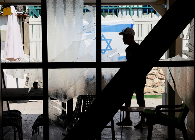 图为以色列北部海滨城镇阿科（Acre）一处公寓在真主党火箭弹及无人机攻击中受损。（路透社）