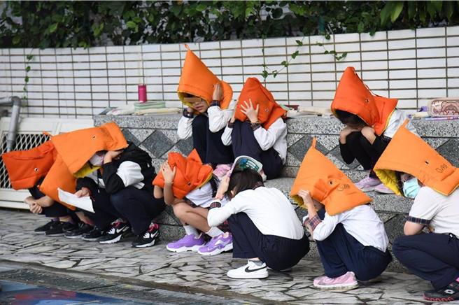 花莲县政府加强校园防灾意识，在开学前採购约2100顶全新防灾头套，将送给国小新生作为入学礼，藉此强化学童防灾能力；图为防灾头套使用示意图。（花莲县政府提供／罗亦晽花莲传真）