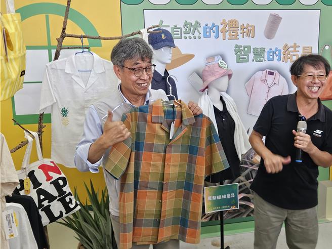 农业部长陈骏季（左）到九如乡农会参访凤梨叶自动化取纤循环场，对于凤梨纤维制成的衣服比讚。（罗琦文摄）