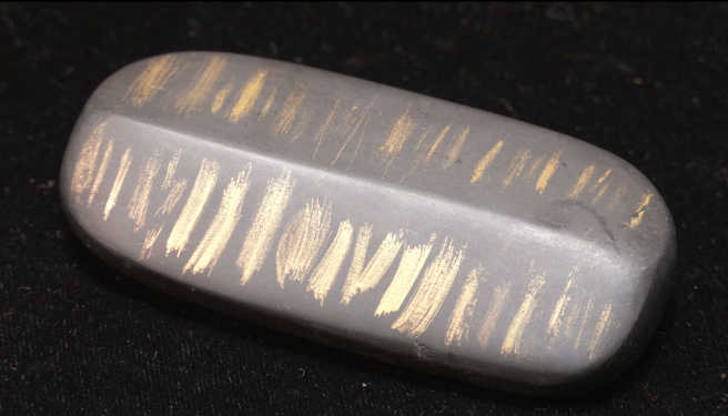 早期科技未发达时，使用「试金石」来测试黄金纯度。磨上去的黄金顏色越沉越黄，纯度就越高。(图/翻摄「中时财知道」)