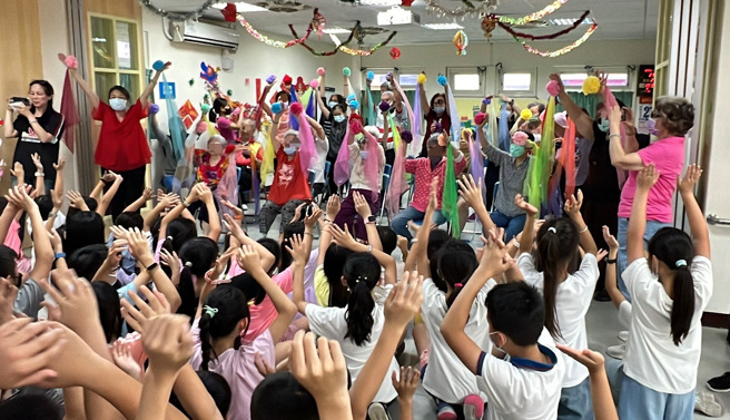 長輩們準備了一首經典歌曲《月亮代表我的心》，不僅演唱了這首歌曲，還教導小朋友們一些簡單的動作。(照片/八里療養院提供)