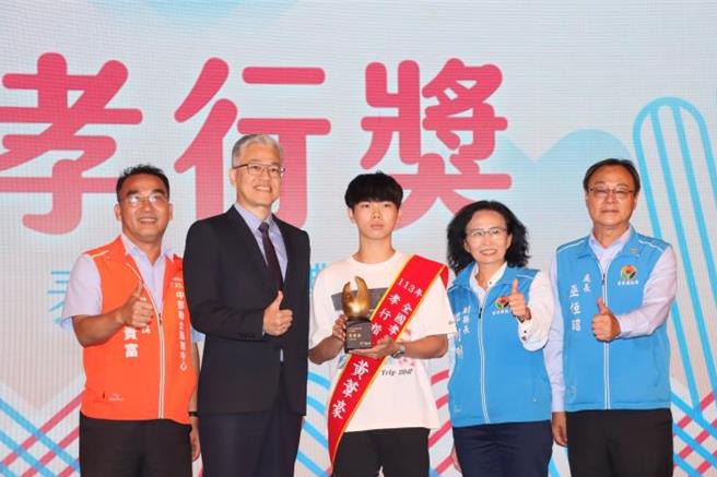 全国孝行奖27日颁奖，苗栗县狮潭学子黄苇豪（中）获奖，接受内政部次长吴堂安（左二）颁奖表扬。（苗栗县政府提供／谢明俊苗栗传真）