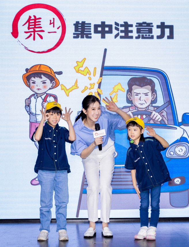 方志友（中）和小朋友示范交通安全撇步。（靖娟基金会提供）