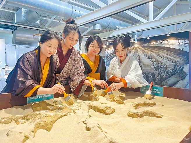 穿着汉服的观眾十分专注地进行考古挖掘体验。（中华翰维文化推广协会提供／李怡芸台北传真）