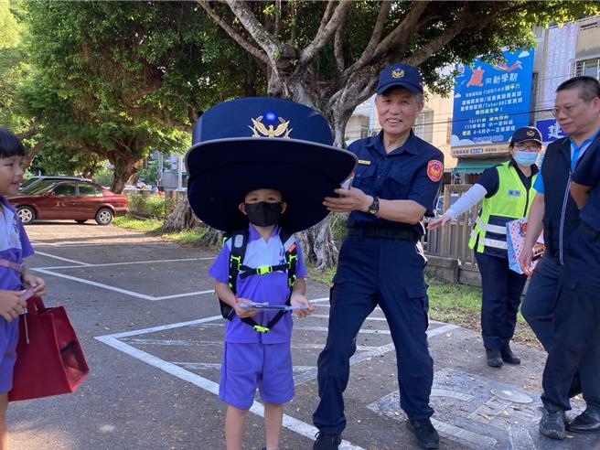 開學日，清水警方帶來「大警帽」，並供學童試戴，小朋友果然賞臉，紛紛搶戴要拍照，稱讚很可愛。（張妍溱攝）