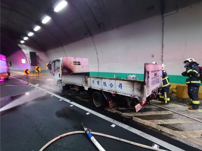 彭山隧道內小貨車後車斗起火，消防人員迅速撲滅火勢。（新北市消防局提供）