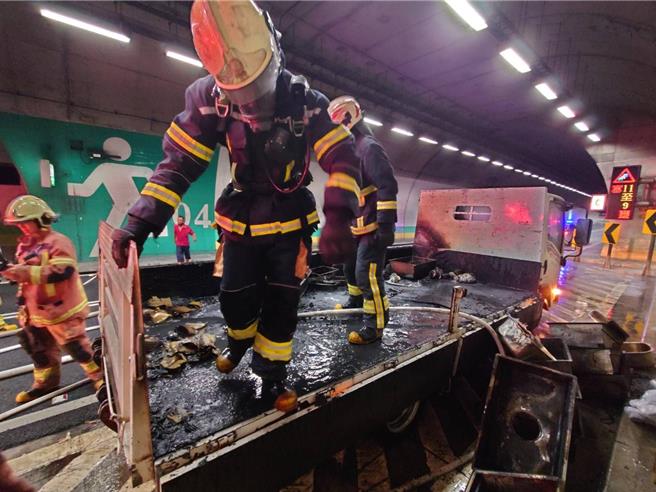 彭山隧道內小貨車後車斗起火，消防人員迅速撲滅火勢。（新北市消防局提供）