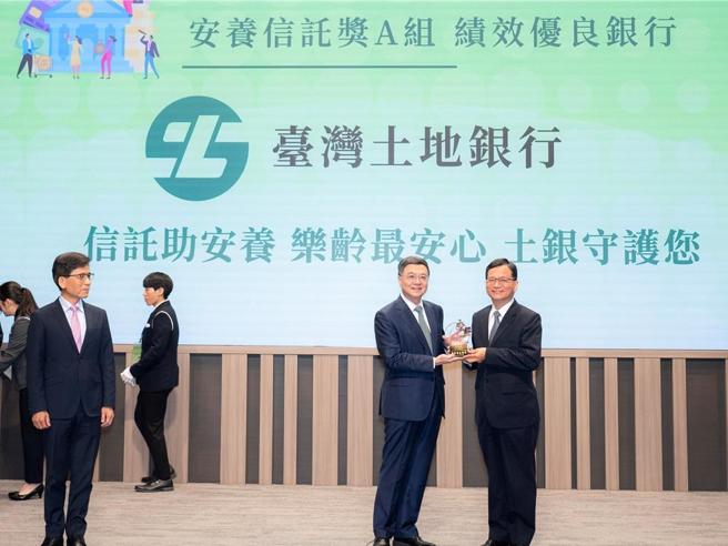 土地银行连3届荣获信托2.0计画评鑑为安养信托绩效优良银行，由行政院长卓荣泰（右2）颁奖，董事长何英明（右1）代表受奖。图／土地银行提供