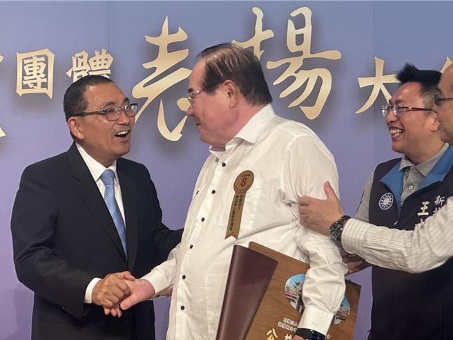 国民党前秘书长李乾龙今（31）日出席绩优宗教团体表扬大会，在台上与新北市长侯友宜互动热络。（柯毓庭摄）