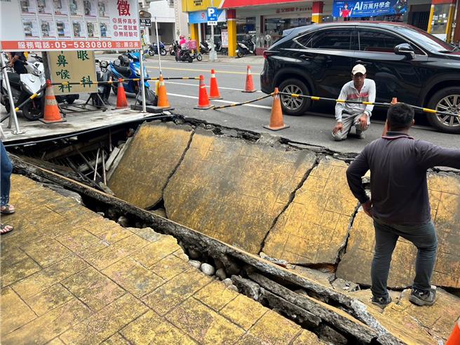 云林县斗六市文化路1家房屋仲介门口路面，31日突然「轰」一声塌陷，出现长约7公尺、宽4公尺、深1.5公尺的「天坑」，幸好当时无人行经，不过有2辆机车掉落坑内受损。（张朝欣摄）