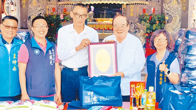 三重先嗇宮董事長李乾龍（右二）代表廟方將普渡供品捐贈給新北市好日子愛心大平台。（呂健豪攝）