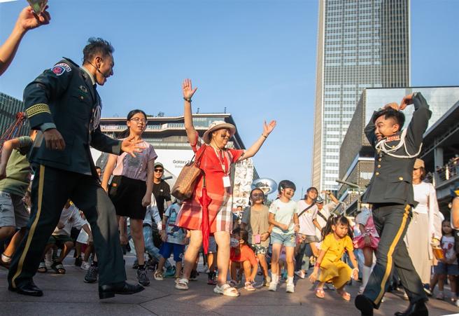 國防部「能戰嘉年華」昨日盛大登場，軍民在臺北101水舞廣場隨著樂曲共舞，並透過軍事攤位體驗互動，齊心歡慶九三。臺北101大樓也在夜間點燈「軍人節快樂」賀詞，向所有捍衛國家安全的官兵致敬。（記者林睿奕攝）