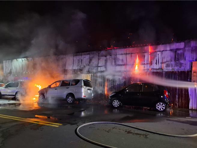 南屯區中和巷閒置鐵皮工廠昨深夜竄火舌，波及周圍數量汽車。（台中市消防局提供）