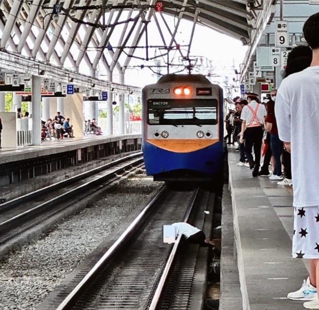 1男自月台掉落趴卧铁轨，刚好1列火车驶进站，生死一瞬间。（翻摄脸书／陈淑芬台中传真）