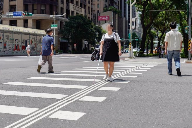新北市近期针对市区重要路口增设「导盲行穿线」，辅以布榖鸟或蟋蟀声的有声号志，让视障朋友能更安全地过马路，交通局依据视障团体的建议，今年起择定30个捷运站优先设置。（柯毓庭摄）
