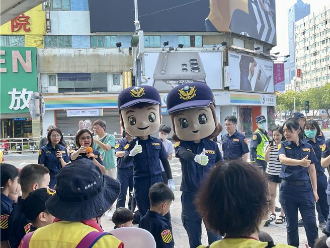 小萌警和吉祥物玩偶「平平、安安」一起劲歌热舞，结合志工共同持手举牌向民眾进行交通安全宣导。（纪爰摄）