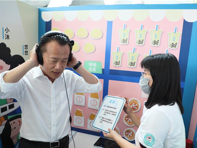 嘉义县长翁章梁体验身障者透过辅具完成工作。（廖素慧摄）