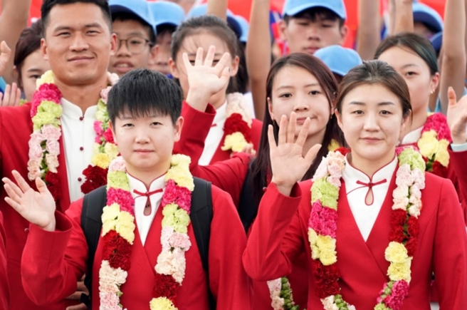 在巴黎奧運奪下桌球3金的孫穎莎（前左）與其他大陸奧運選手抵達澳門時成為媒體採訪熱門人物。（圖／騰訊體育）